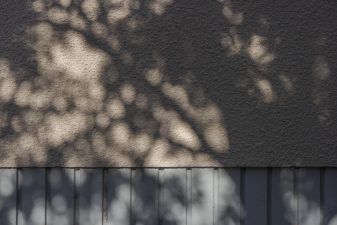 Kuvituskuva, puiden varjo seinustalla