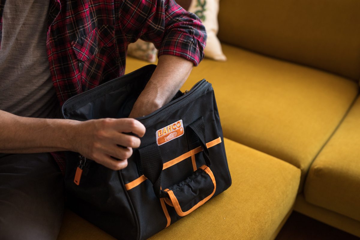 Henkilön kädet etsivät jotakin Energiaeksperttisalkun sisältä